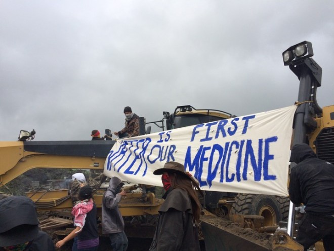 Activists swarmed a Dakota Access construction site on Tuesday morning, unfurling banners and leading several dozen people, including Green Party presidential candidate Jill Stein, in song and prayer. Law enforcement officers stood back and observed the scene as two activists chained themselves to excavators; construction workers vacated the site without comment.