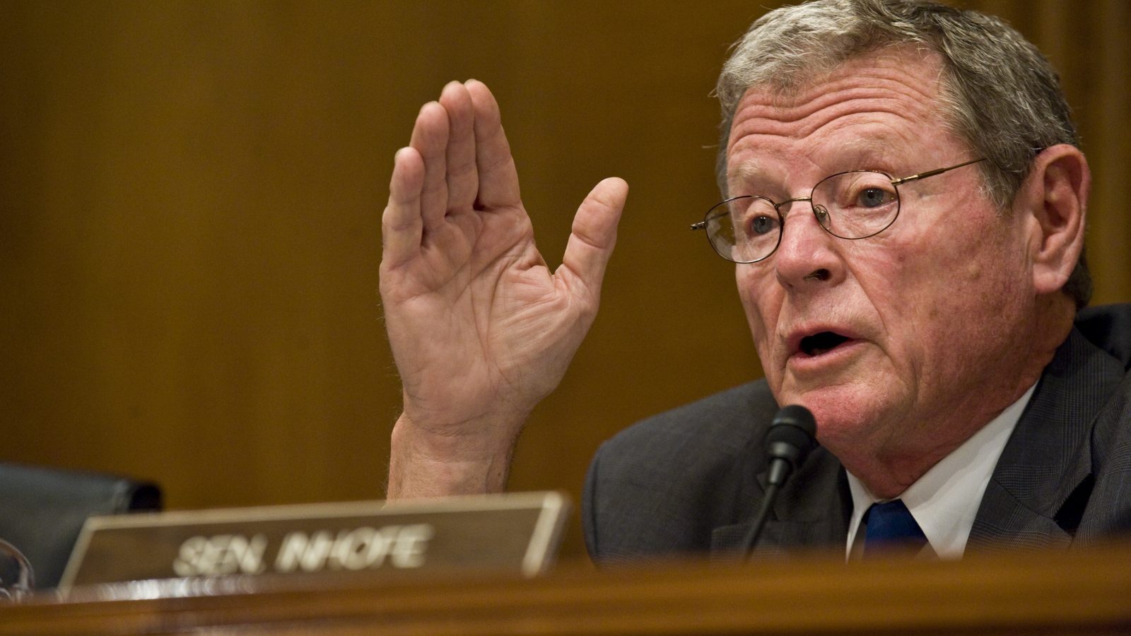 A photo fo James Inhofe with his hand in the air