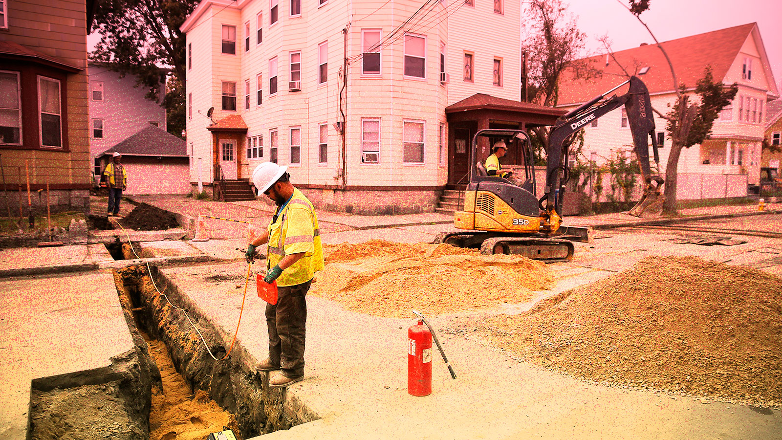 Photo of construction worker next to natural gas trench