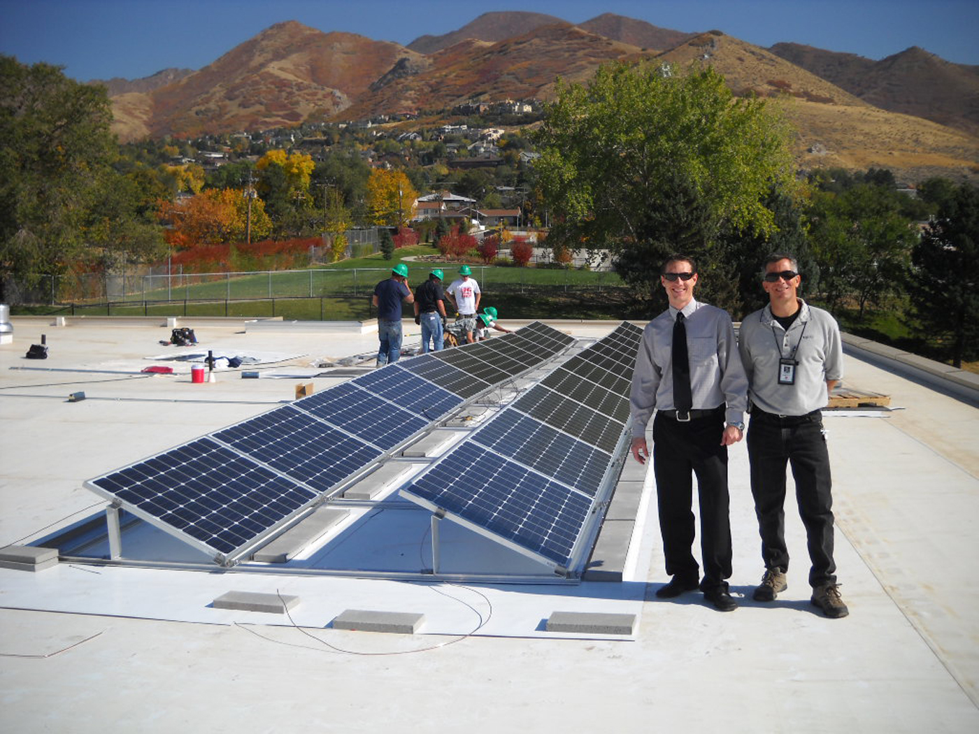 Two men standing near solar panels