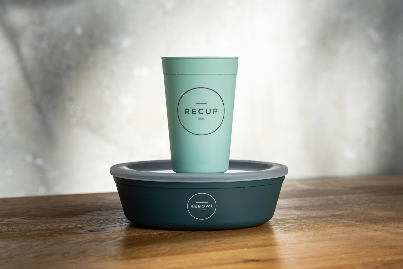 a green cup on top of a green bowl. Both are labeled ReCUP