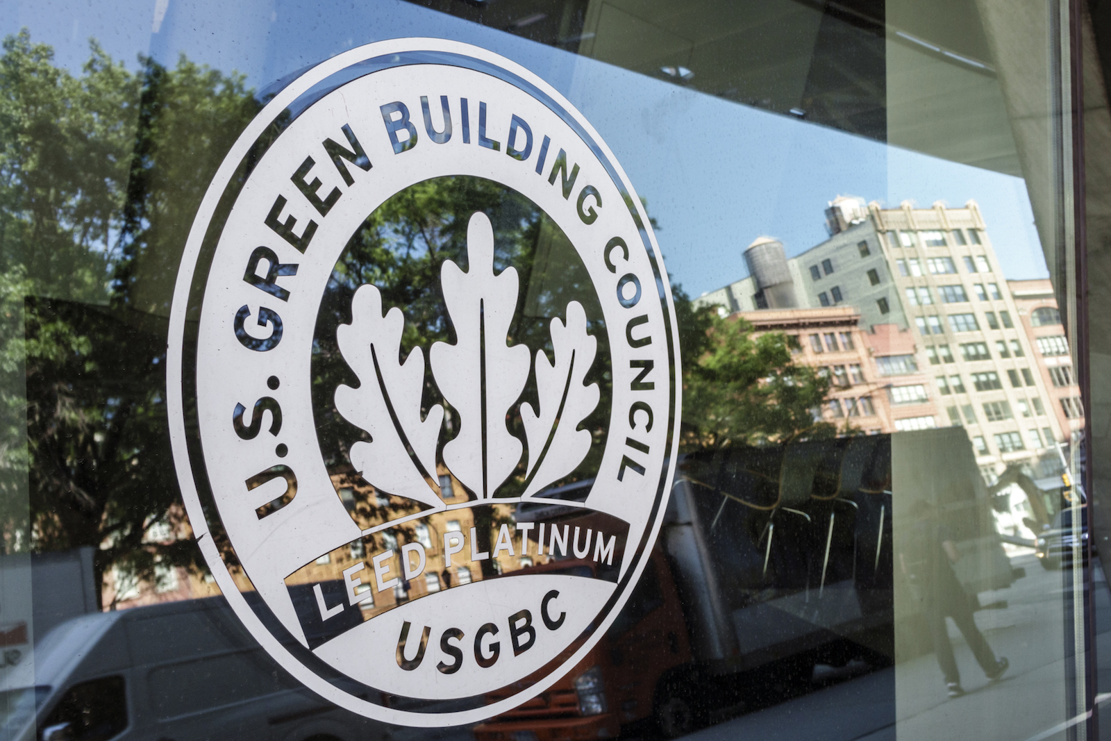 a logo for the US Green building Council on a door -- with three leaves in the center of the design