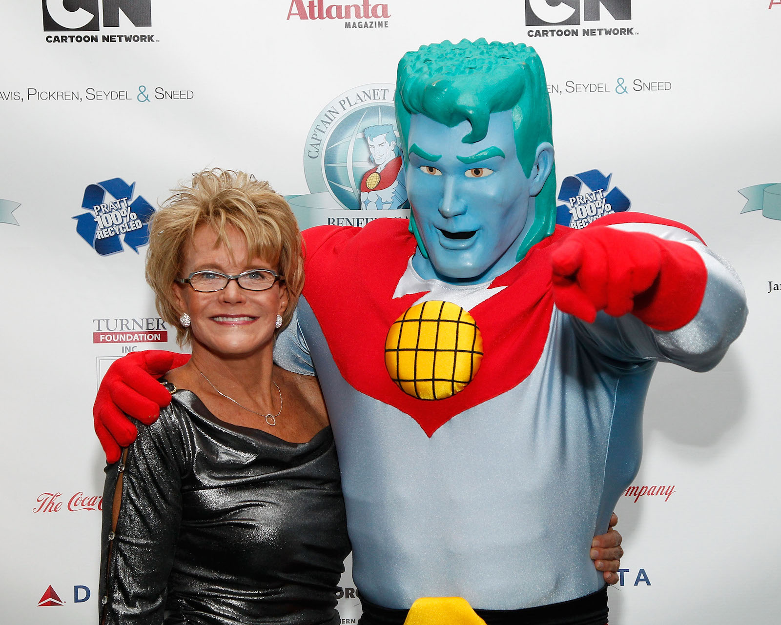 a woman in a sparkly dress on the left, a person in a captain planet costume with green hair, blue skin, and a red half-shirt on the right