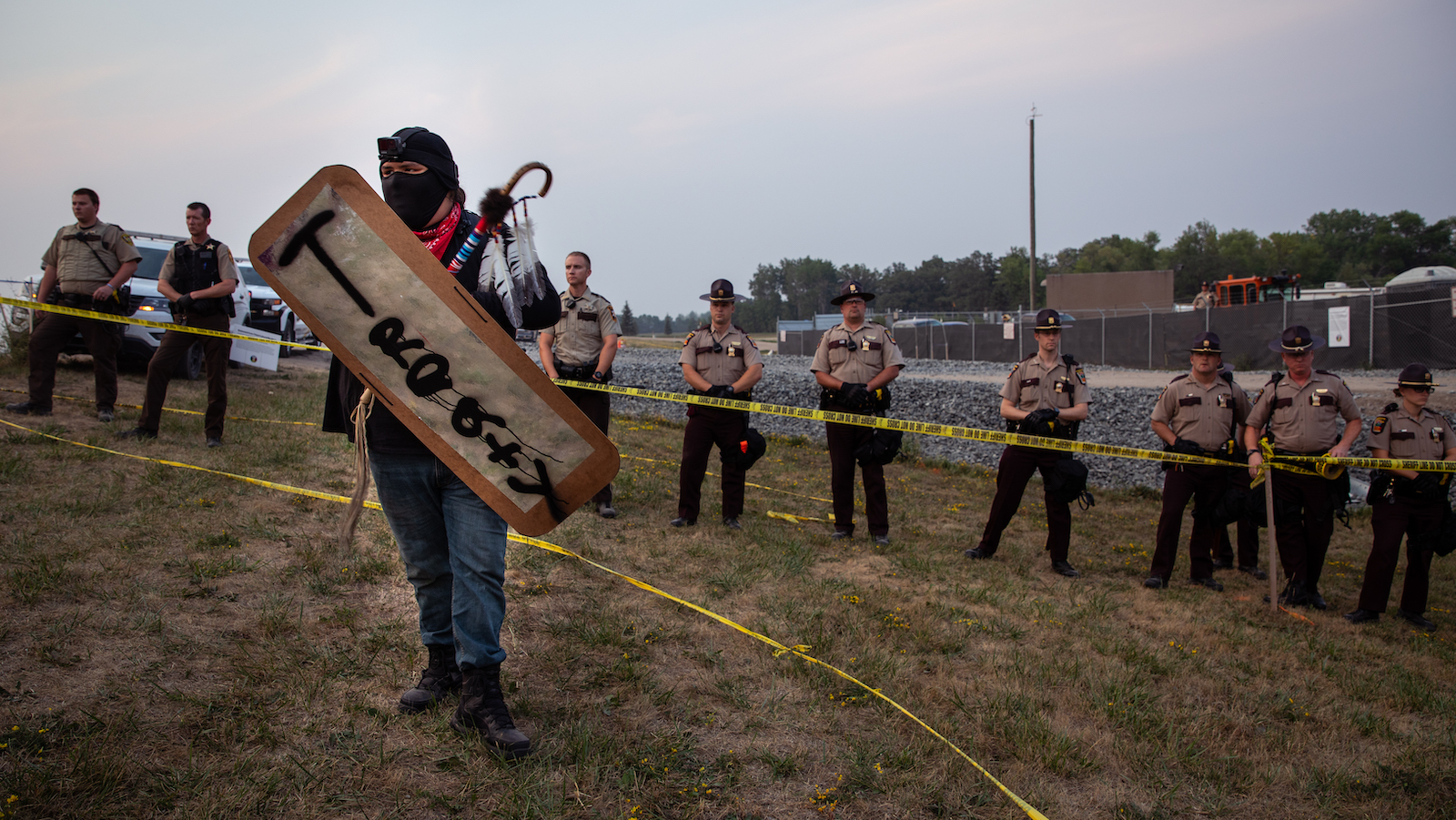 A protestor holds a sign reading "Treaty" at a drill site on the Red Lake River.