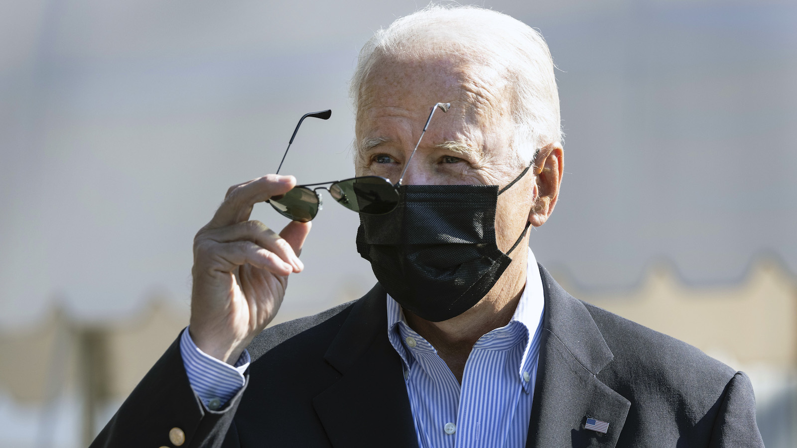 Joe Biden puts on his sunglasses under the blazing sun