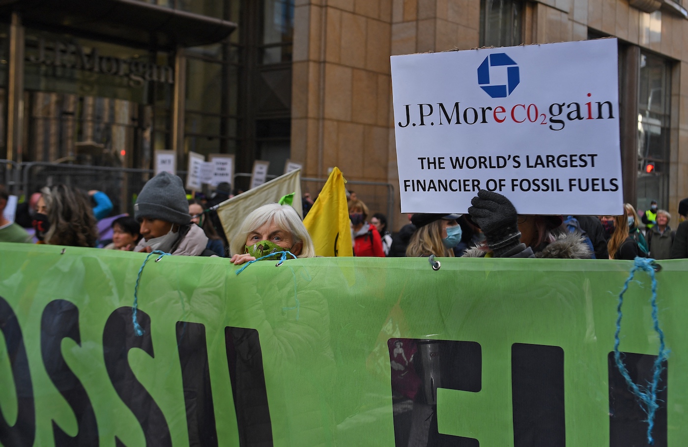Protestors outside of the JP Morgan Chase building in glasgow. A sign reads "the world's largest financier of fossil fuels."