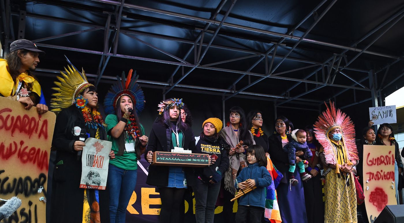 Youth activists from indigenous communities in the Brazilian Amazon give speeches on a stage during a protest