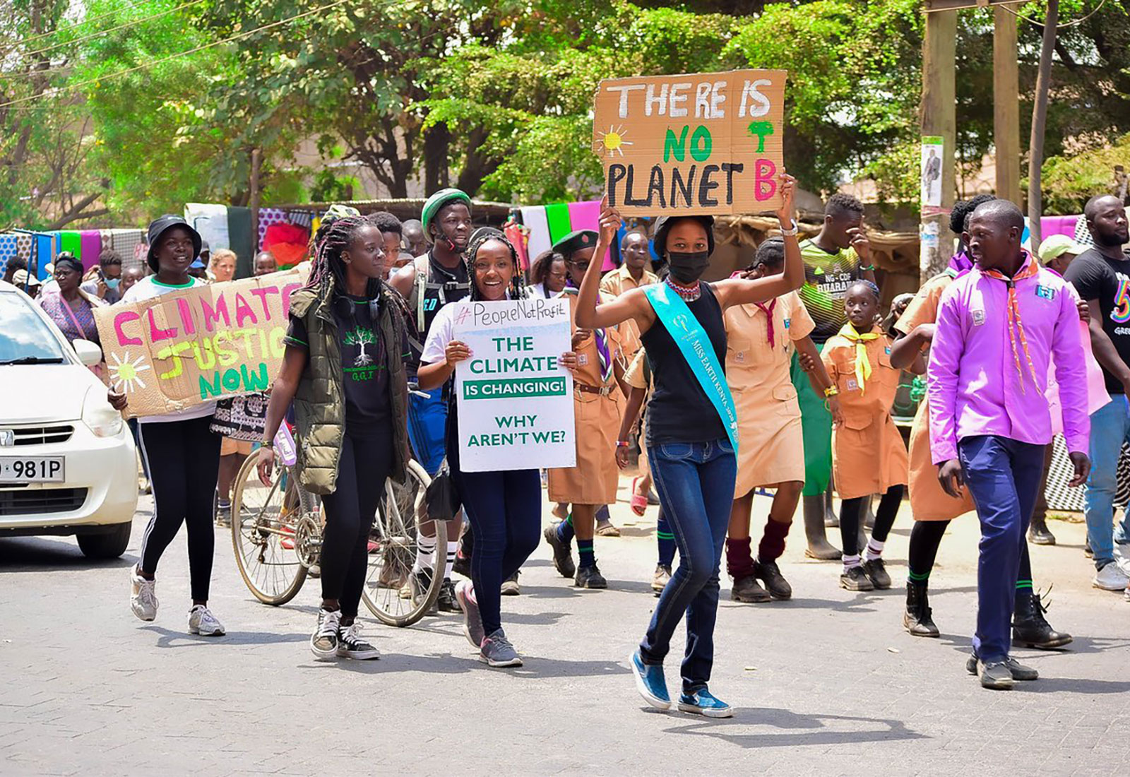 Large group of people in Nairobi, Kenya, walking down a street holding signs protesting climate change