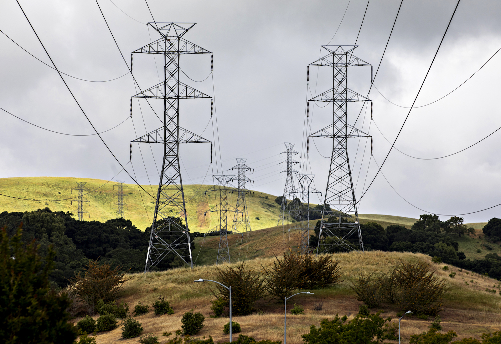 Transmission cables on rolling hills and cloudy skies