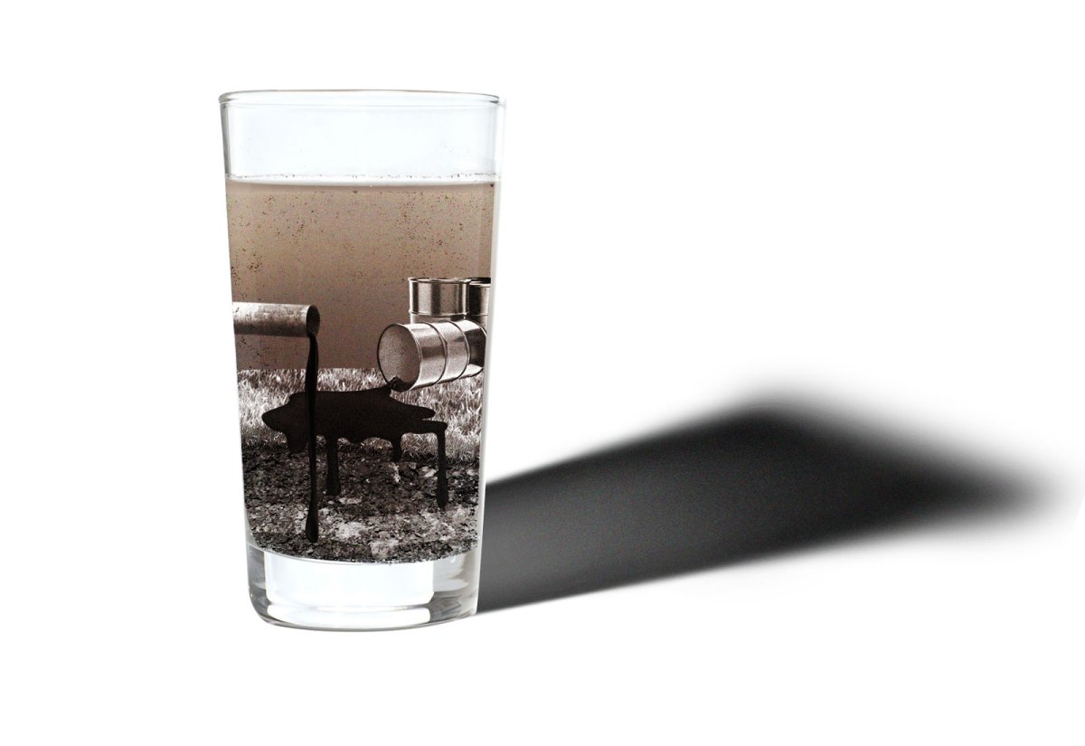 Cup of dirty water with collage of pipe and barrels leaking black liquid that is seeping into the ground