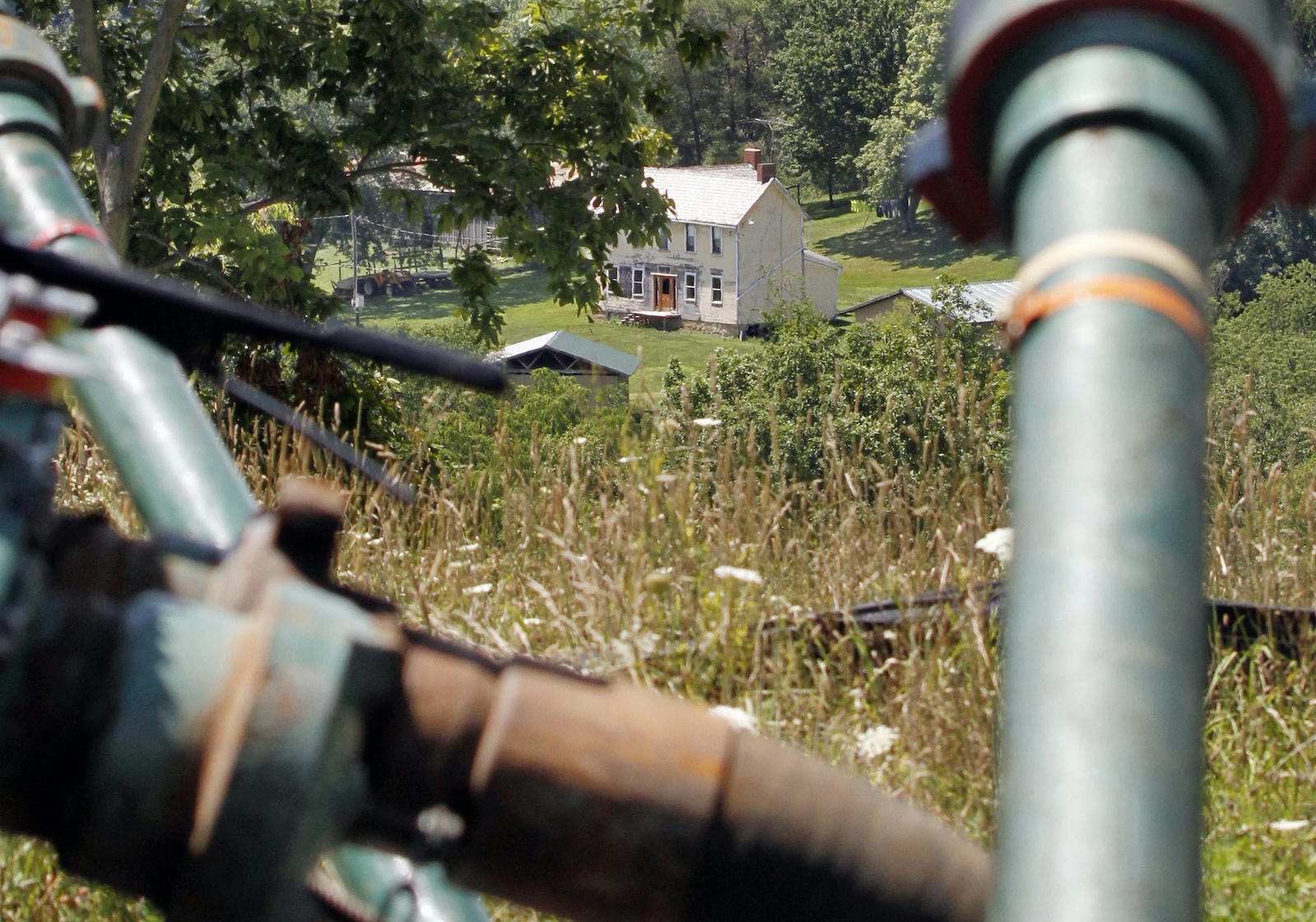 a farmhouse in the background, pipes in the foreground