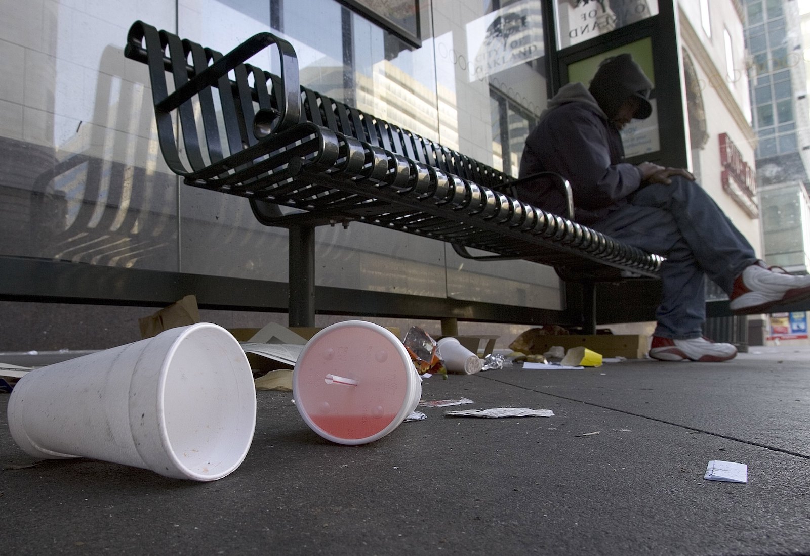 Used polystyrene cups below a park bench