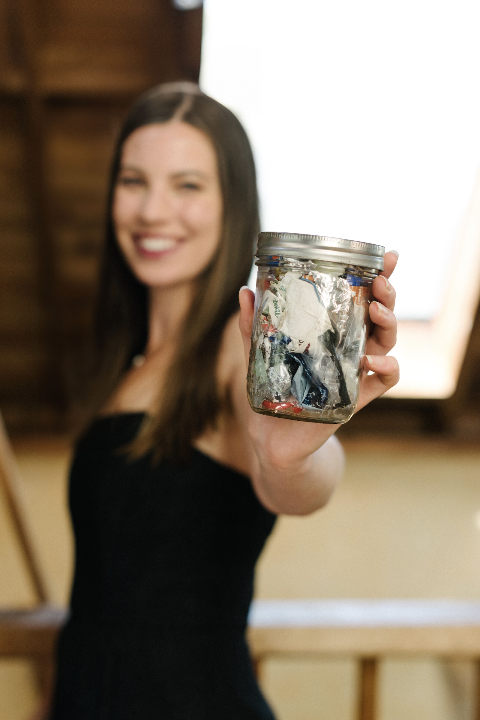 Woman holds a trash jar up to the camera