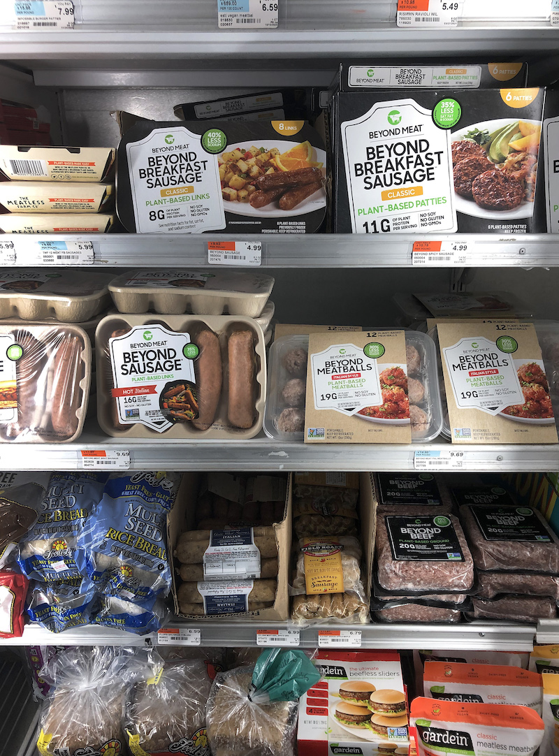 a freezer aisle with beyond beef patties and sausage products