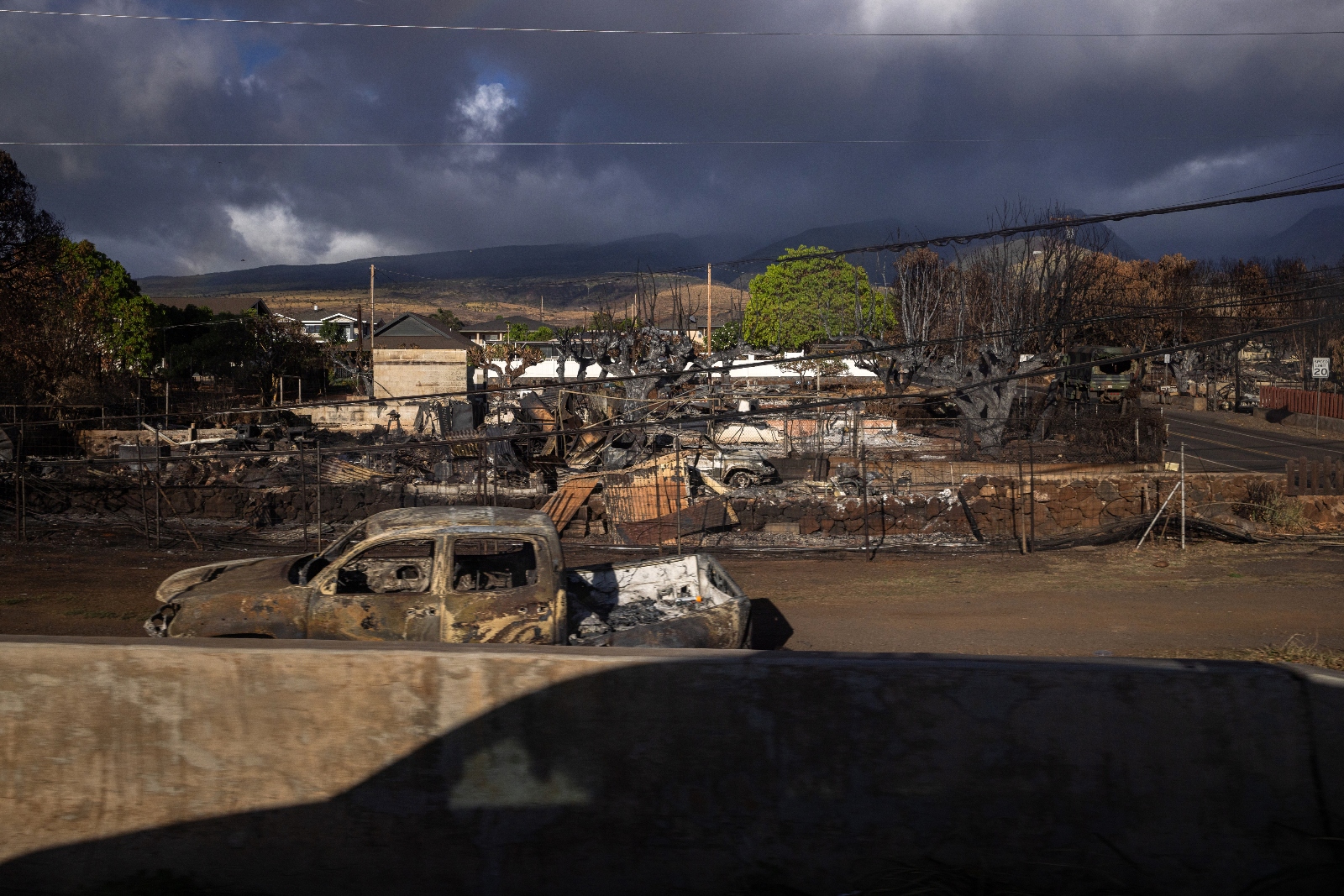 Victoria Gladden and her daughters drive past homes that were burned in the August wildfires that destroyed much of Lahaina, Hawaiʻi.