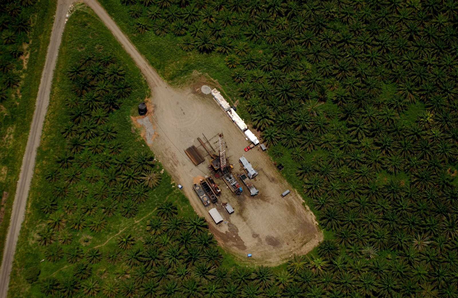 an aerial view of an oil rig in a deforested area in the jungle